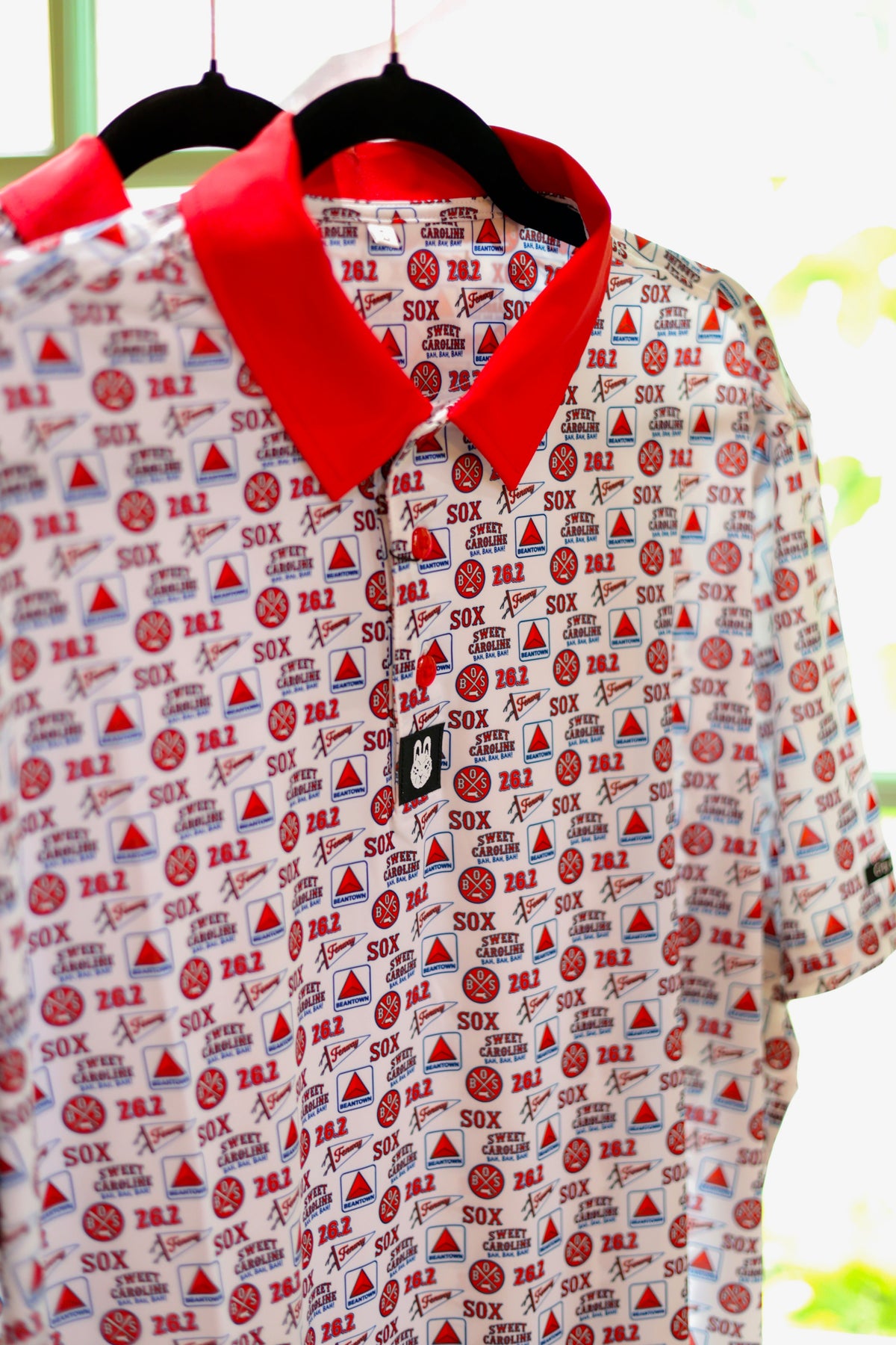 Front view of The Fenway Classic Polo featuring a bright red collar and an all-over Boston baseball-inspired print with classic Fenway details.