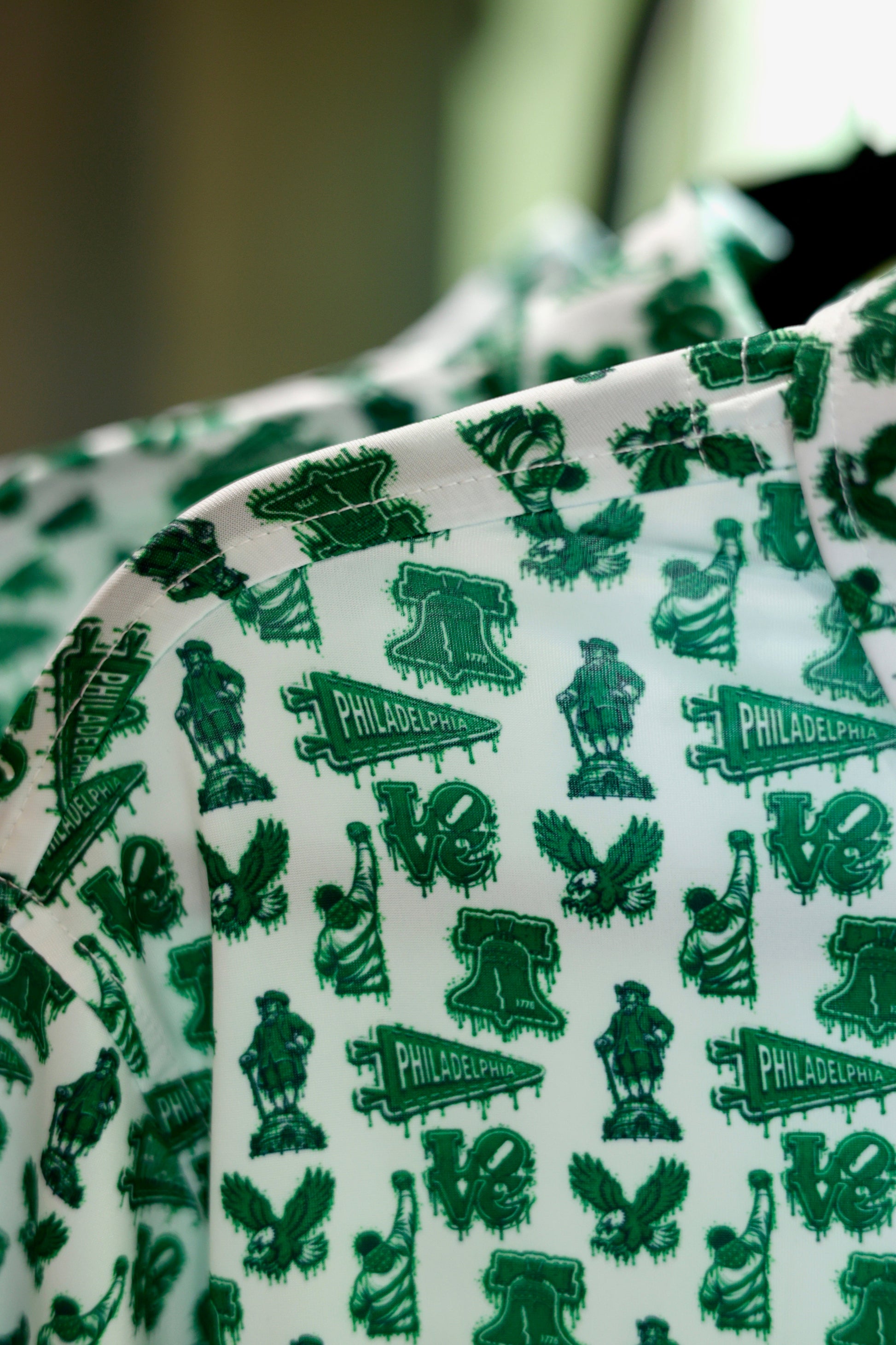 Close-up of The Bleeding Green Polo collar highlighting the all-over Philadelphia-inspired Kelly green print on premium performance fabric.