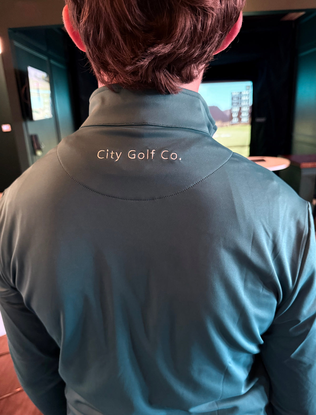 The Philly Heritage Zip Up, dark teal smooth athletic quarter-zip with a stand collar and “City Golf Co.” embroidery at the back
