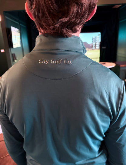 The Philly Heritage Zip Up, dark teal smooth athletic quarter-zip with a stand collar and “City Golf Co.” embroidery at the back
