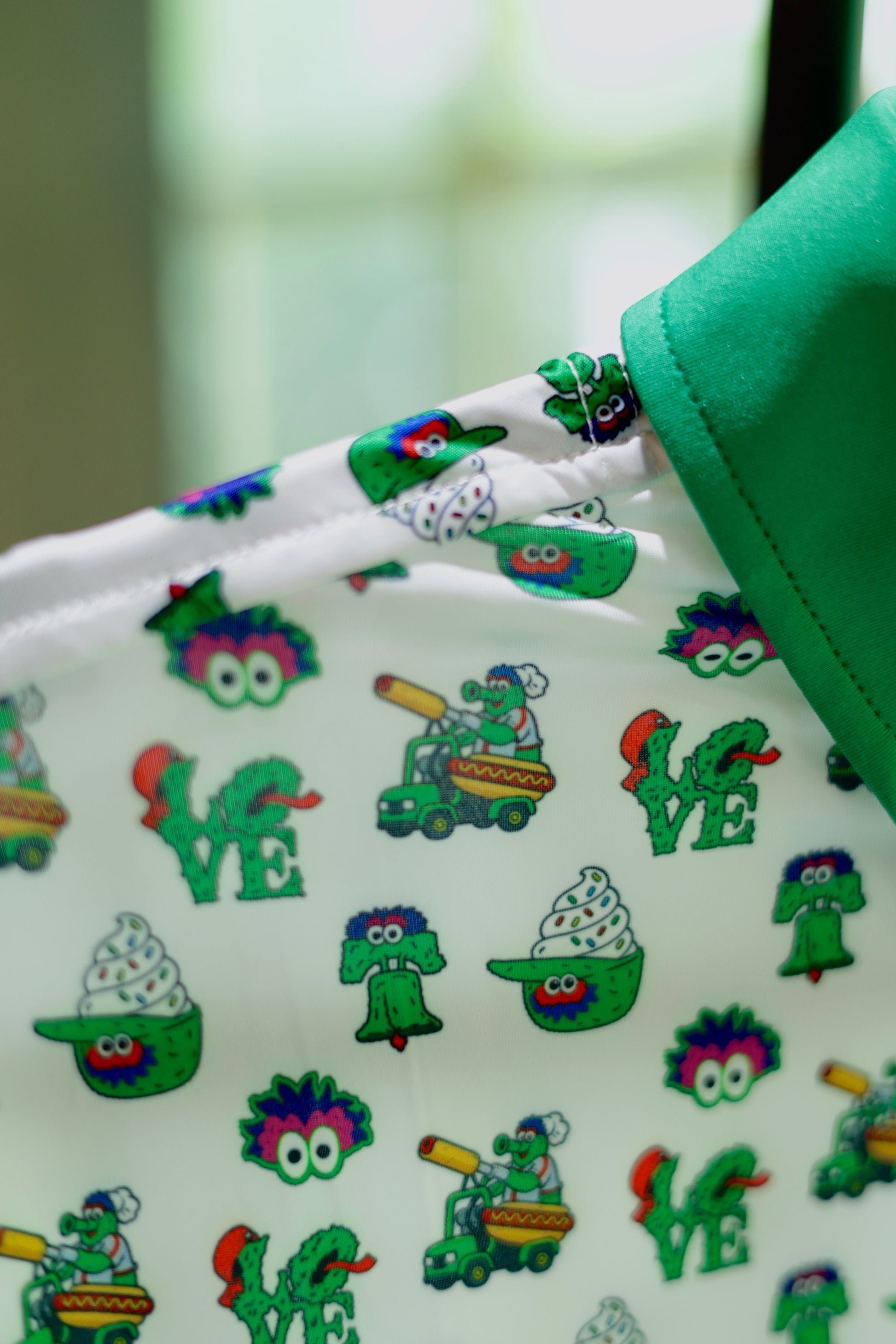 Front view of The Green Menace Polo highlighting the bright green collar, all-over Philadelphia-inspired print, and lightweight performance golf fabric.