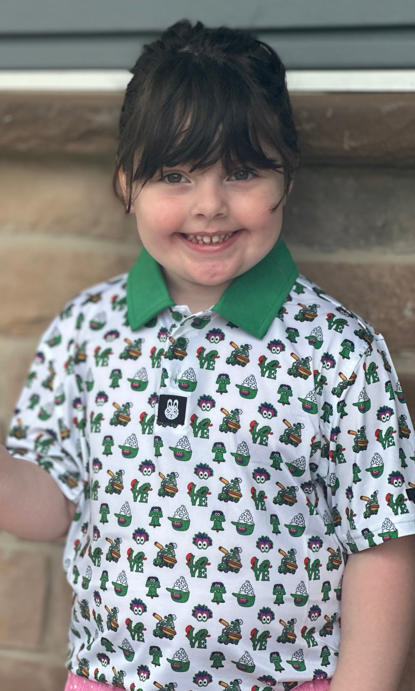 Front view of The Green Menace Children's Polo featuring a playful Philadelphia-inspired baseball design on a lightweight performance golf polo for kids.