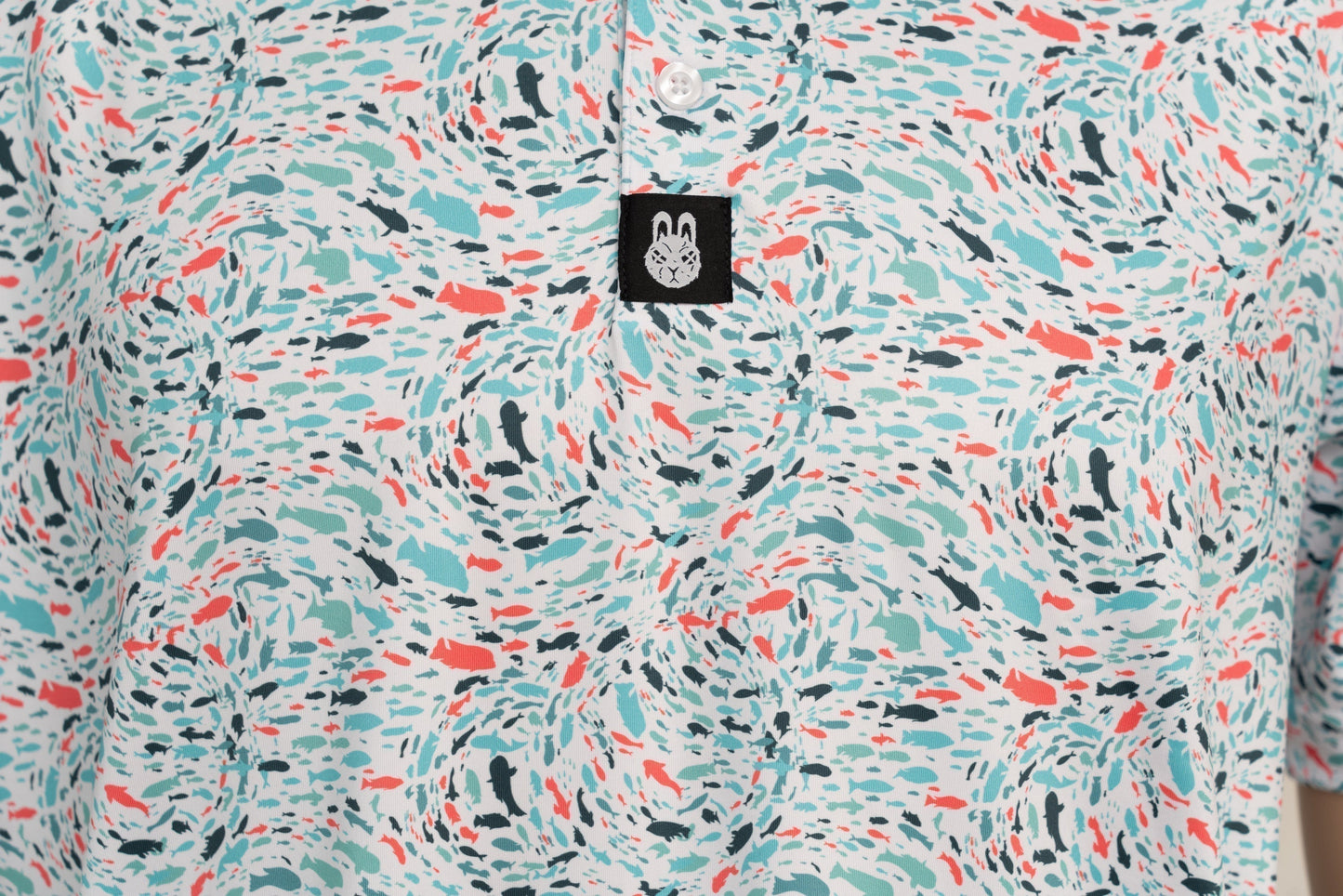 Close-up of button placket, showing structured neckline and subtle branding on the Fish 'n' Chips golf shirt.