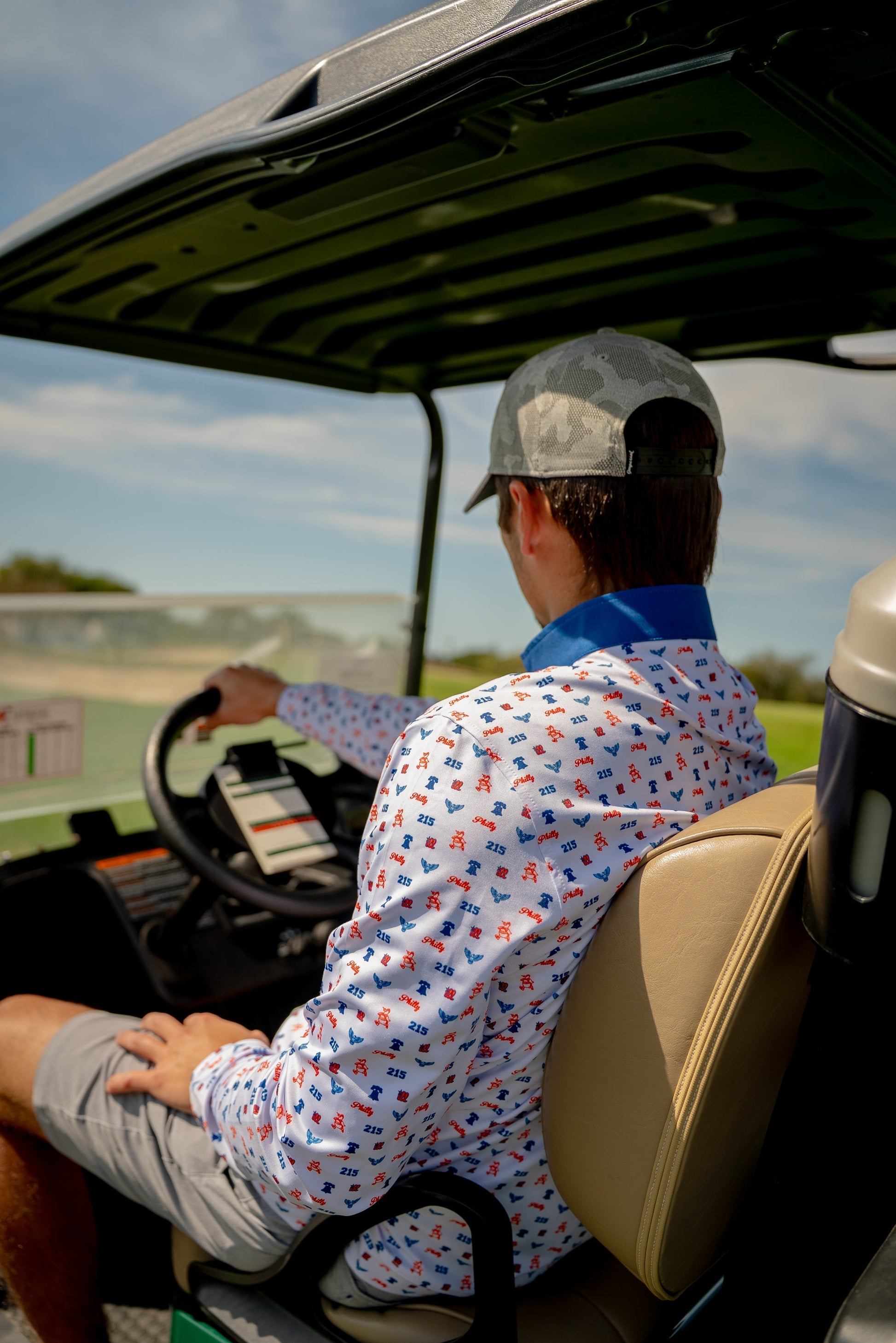 Side view of model wearing The Phrenetic Zip Quarter Zip men’s golf pullover by City Golf Collective while sitting in a golf cart