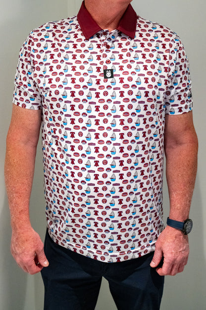 Front view of City Golf Collective Philadelphia-inspired performance golf polo featuring vintage-inspired all-over graphics, maroon collar, athletic fit, and lightweight performance material.