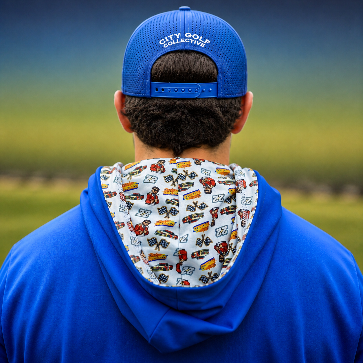 City Golf Collective Mallozzi Motors Hoodie worn by model back view showing blue fabric and racing pattern inside hood with cars flags and driver graphics