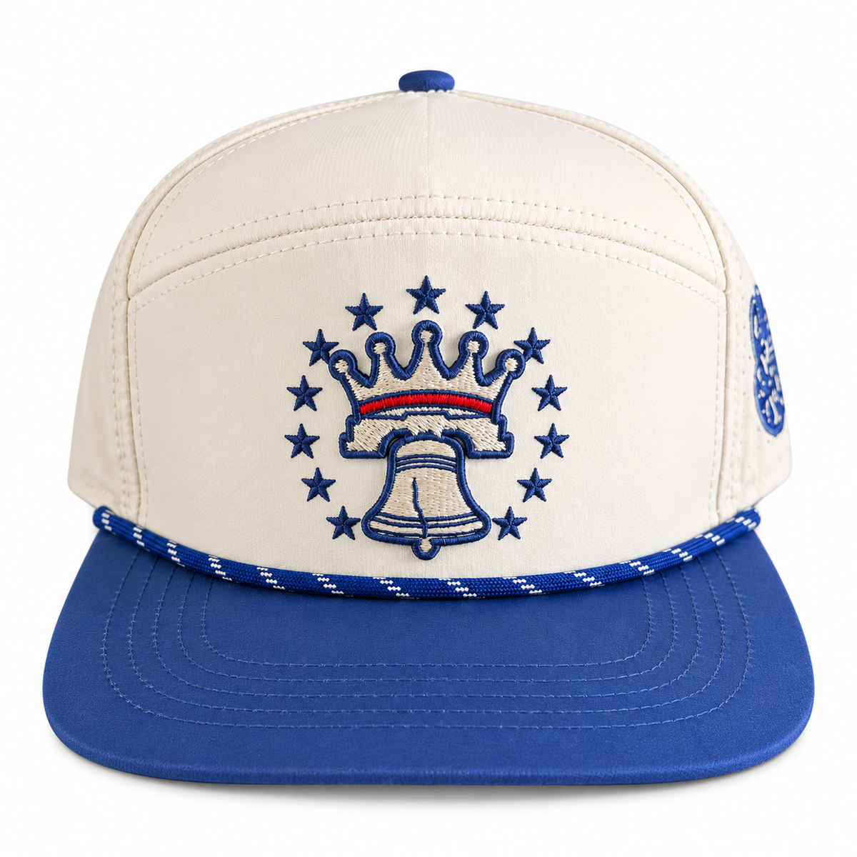 Front view: Cream and navy rope hat featuring a crowned Liberty Bell emblem with surrounding stars and a curved navy brim.